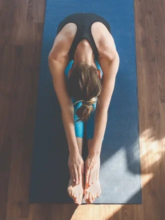Woman doing yoga in a light-filled studio at The Strathmore’s New York luxury apartments.